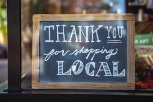 Sign in store window that reads thank you for shopping local